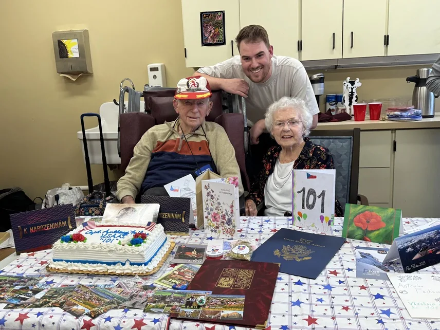 Antonín Fajkus with Jiri Kluc at his 101st birthday celebration, surrounded by cards and gifts.
