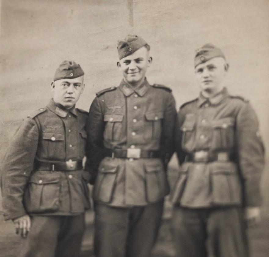 Three German soldiers in a wartime group photograph.