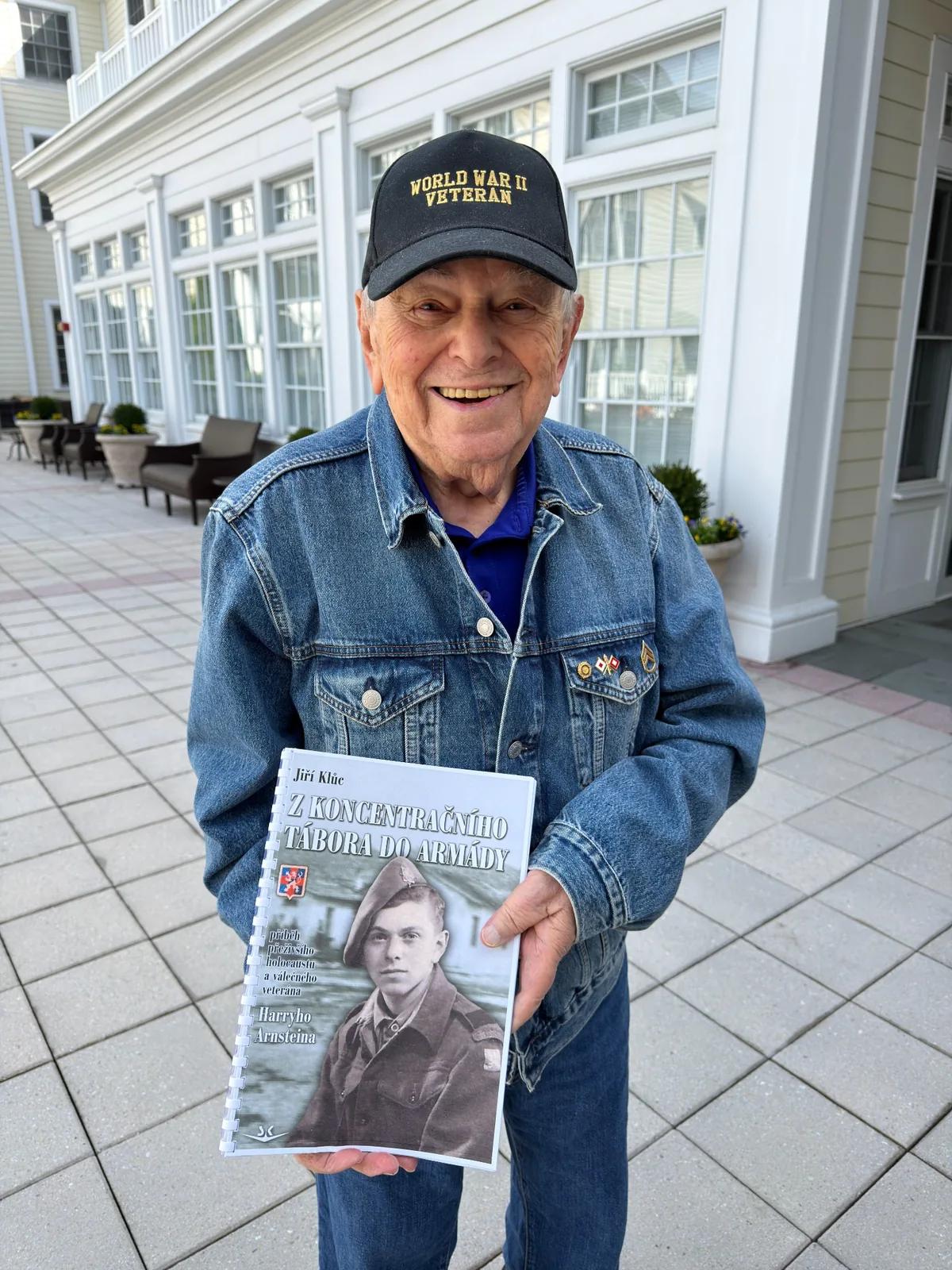 Harry Arnstein holding Jiri Kluc’s book about his experiences.