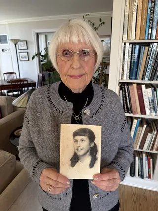Eva Kessner holding a photograph of herself as a young girl.