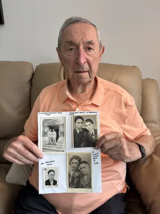 Fred Zeilberger holding a display of family photographs.