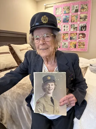 Marie Warren holding her wartime portrait.