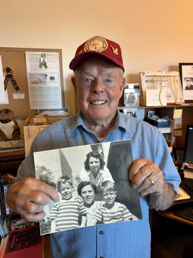 Tom Crosby holding a historical family photograph.