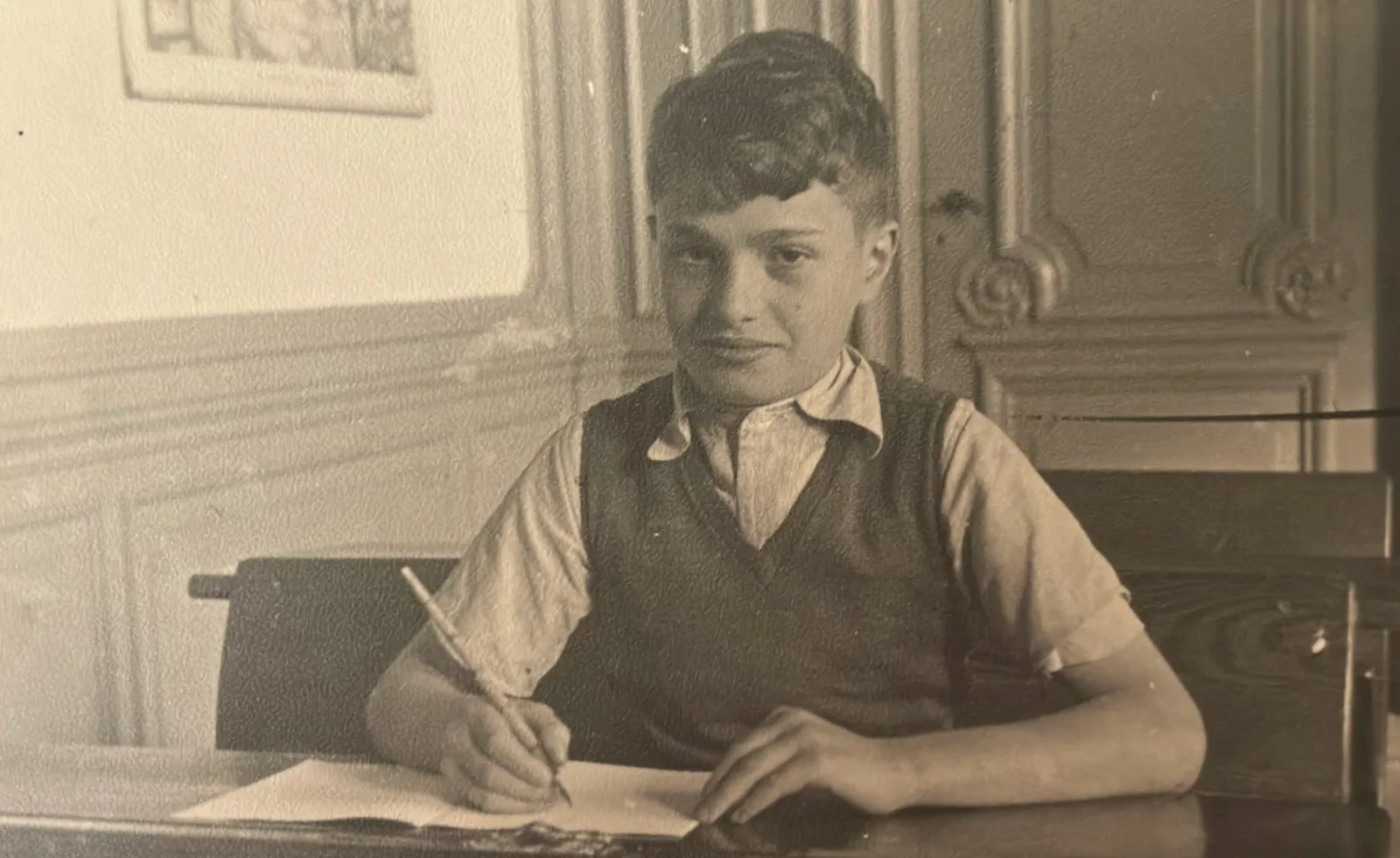 Ronald Waterman as a child, seated at a desk.